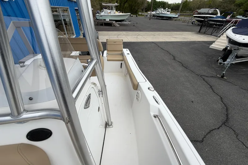 Slide: The Image of 2017 Tidewater 198 CC Adventure boat interior with seating and railing, parked outdoors. - 8