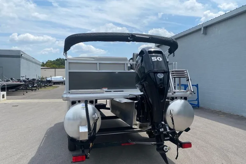 Slide: The Image of 2026 Sun Tracker Bass Buggy 16 XL Select pontoon boat with 50 HP motor, parked outdoors. - 85