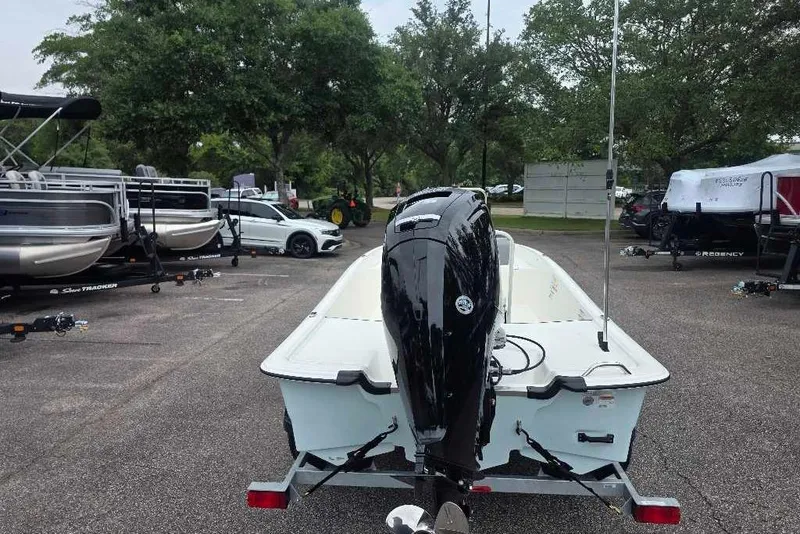 Slide: The Image of 2026 Mako Pro Skiff 17 CC boat on trailer in parking lot with trees. - 5