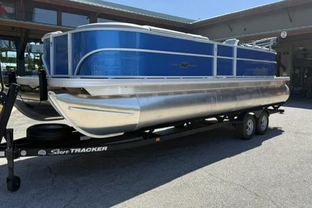 The Image of 2026 Sun Tracker Party Barge 24 XP3 pontoon boat on trailer, parked outdoors. - 0