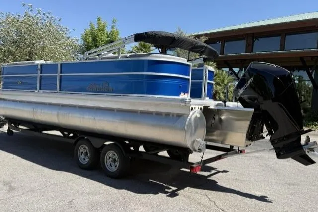 Slide: The Image of 2026 Sun Tracker Party Barge 24 XP3 pontoon boat on trailer, parked outdoors. - 3
