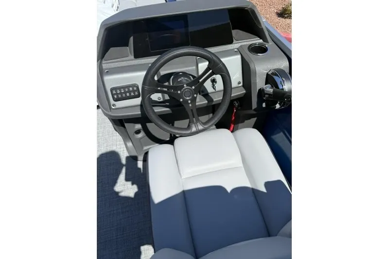 Slide: The Image of 2026 Sun Tracker Party Barge 24 XP3 helm with steering wheel and control panel. - 7