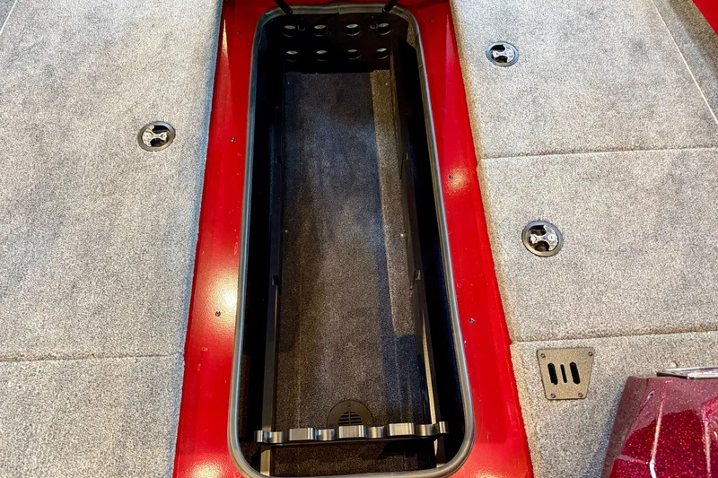 Slide: The Image of 2026 Ranger RT188P boat storage compartment with red trim and carpeted interior. - 14