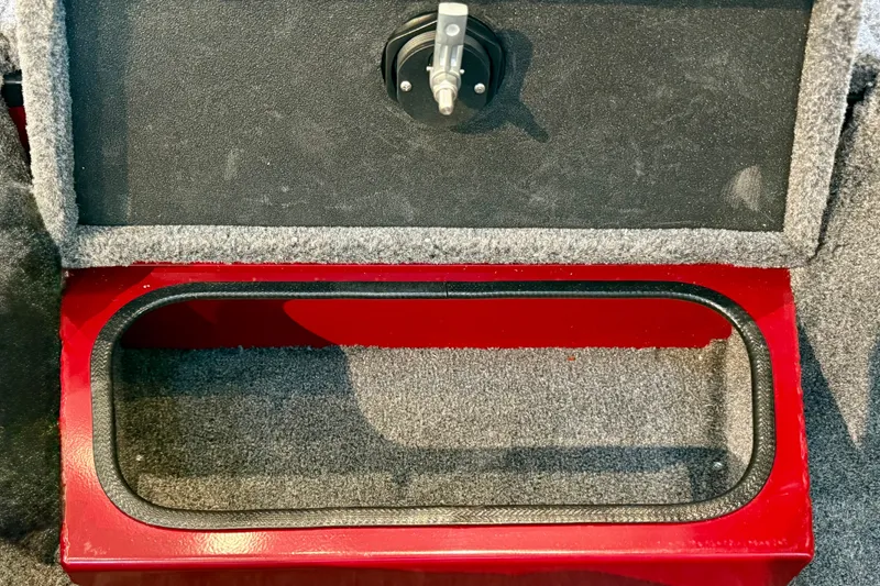 Slide: The Image of Open storage compartment in 2026 Ranger RT188P boat, featuring red and gray interior. - 18