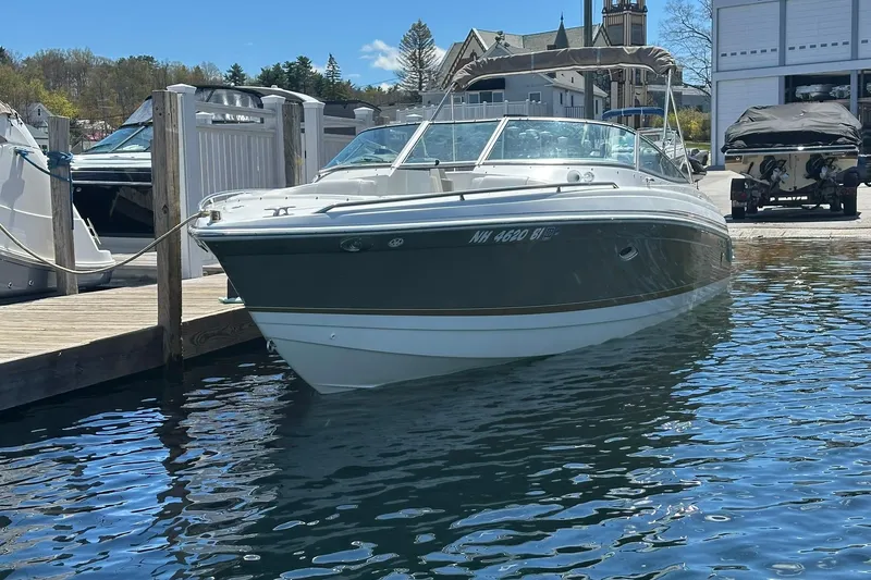 The Image of 2004 Formula 260 Bowrider docked at a marina, surrounded by calm water. - 0