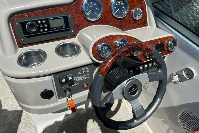 Slide: The Image of 2004 Formula 260 Bowrider dashboard with wood accents and steering wheel. - 11