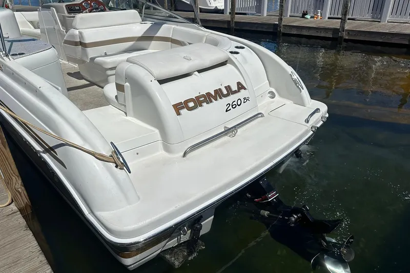 Slide: The Image of 2004 Formula 260 Bowrider boat docked, showcasing sleek design and spacious seating. - 5