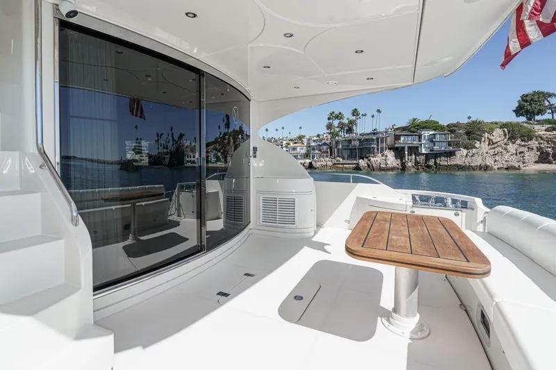 Slide: The Image of Luxurious 2005 Marquis 65 yacht deck with wooden table, coastal view, and modern design. - 38
