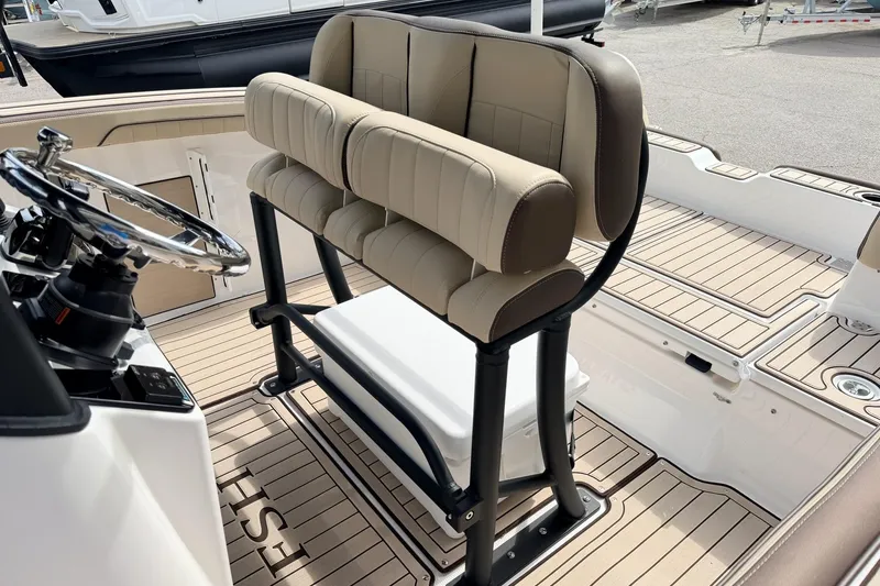 Slide: The Image of 2026 Yamaha Boats 255 FSH Sport H helm with cushioned seating and sleek steering wheel. - 10