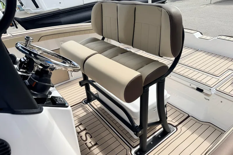 Slide: The Image of 2026 Yamaha Boats 255 FSH Sport H interior with beige seating and steering wheel. - 11
