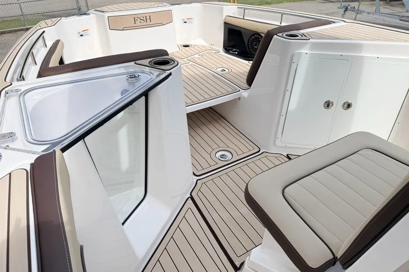 Slide: The Image of 2026 Yamaha Boats 255 FSH Sport H interior with sleek seating and storage compartments. - 13
