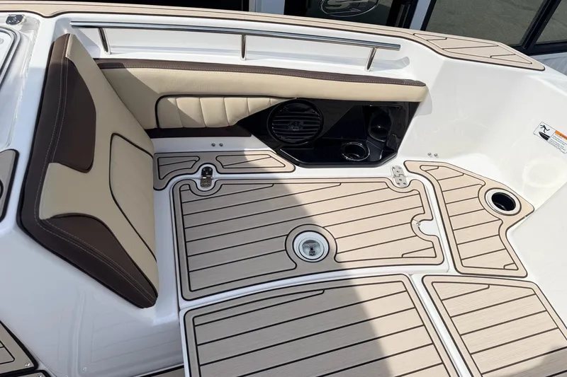 Slide: The Image of 2026 Yamaha Boats 255 FSH Sport H interior with beige and brown seating, sleek flooring design. - 17