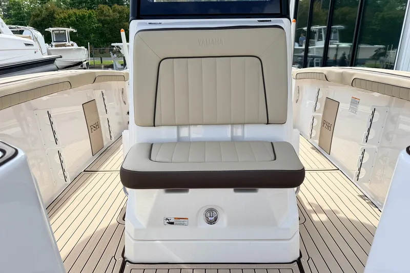 Slide: The Image of 2026 Yamaha Boats 255 FSH Sport H interior with beige seating and sleek design. - 19