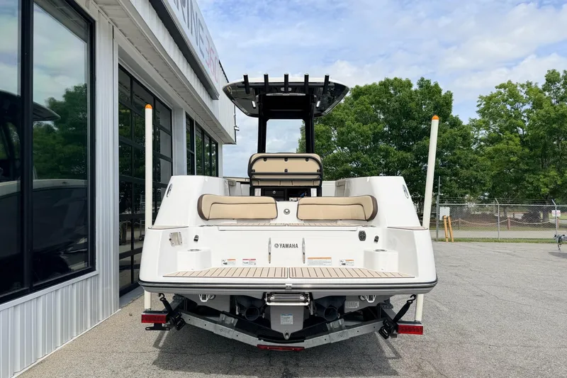Slide: The Image of 2026 Yamaha Boats 255 FSH Sport H, rear view at dealership, sunny day. - 2