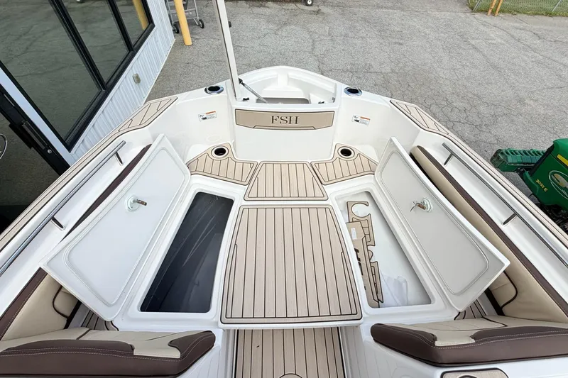Slide: The Image of 2026 Yamaha Boats 255 FSH Sport H deck with storage compartments open, showcasing sleek design. - 22