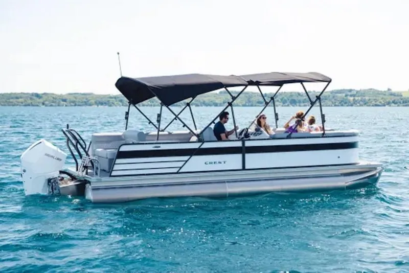The Image of 2022 Crest Classic DLX 220 SLS pontoon boat cruising on a lake. - 1