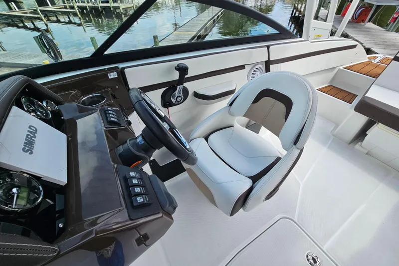 Slide: The Image of 2020 Monterey M-225 boat interior with steering wheel and captain's chair. - 12