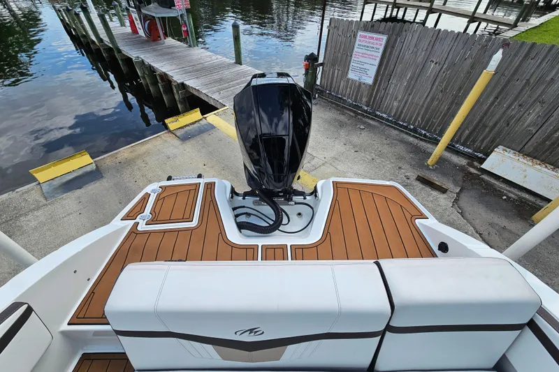 Slide: The Image of 2020 Monterey M-225 boat with outboard motor at dockside, featuring teak-style decking. - 14