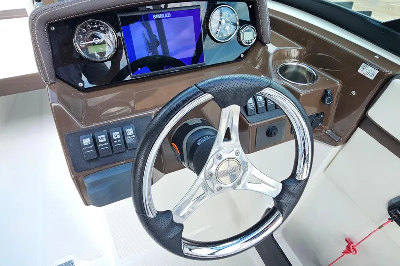 Slide: The Image of Steering console of 2020 Monterey M-225 boat with Simrad display and control switches. - 19