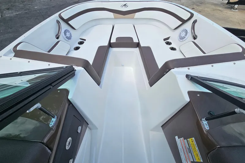 Slide: The Image of 2020 Monterey M-225 boat interior with white and brown seating, cup holders, and speakers. - 22