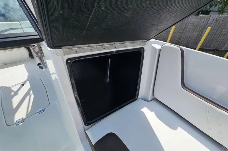 Slide: The Image of Open storage compartment on a 2020 Monterey M-225 boat with white seating. - 25