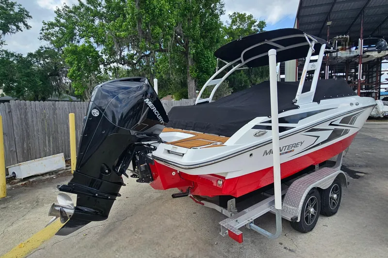 Slide: The Image of 2020 Monterey M-225 boat with Mercury outboard engine on a trailer, parked outdoors. - 3
