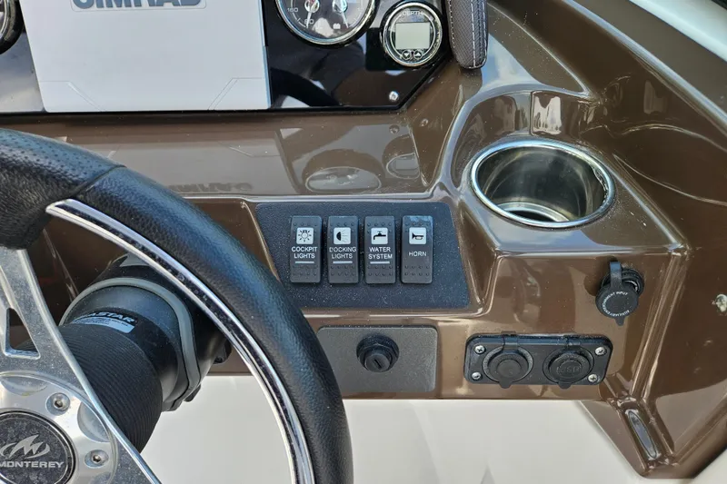 Slide: The Image of Dashboard of a 2020 Monterey M-225 boat with controls and cup holder. - 30