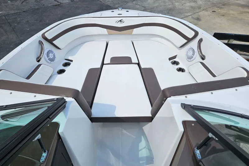 Slide: The Image of 2020 Monterey M-225 boat interior with white and brown seating, cup holders, and speakers. - 8