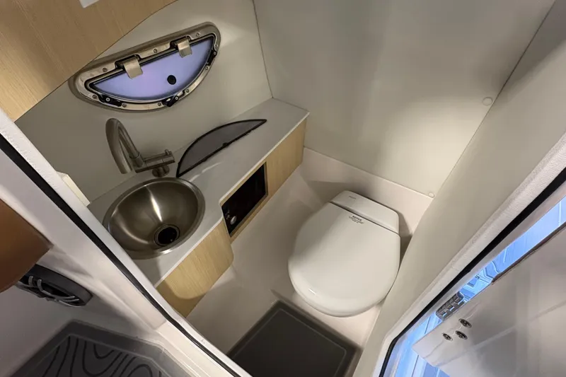 Slide: The Image of Compact bathroom in 2026 Regal LS6 boat with sink, toilet, and porthole window. - 11