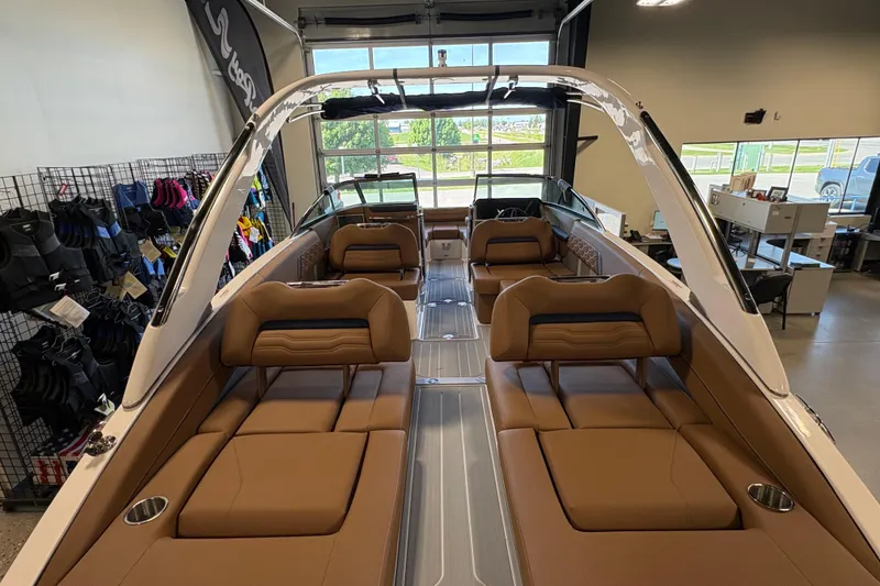 Slide: The Image of 2026 Regal LS6 boat interior with tan seating and modern design in showroom. - 19