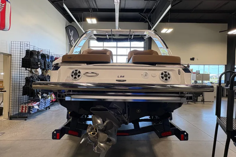 Slide: The Image of 2026 Regal LS6 boat in showroom, rear view with propeller and seating. - 2
