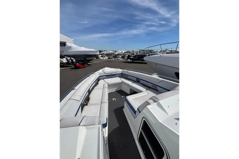 Slide: The Image of 2018 Formula 330 Crossover Bowrider I/O with spacious seating, docked under a clear blue sky. - 11