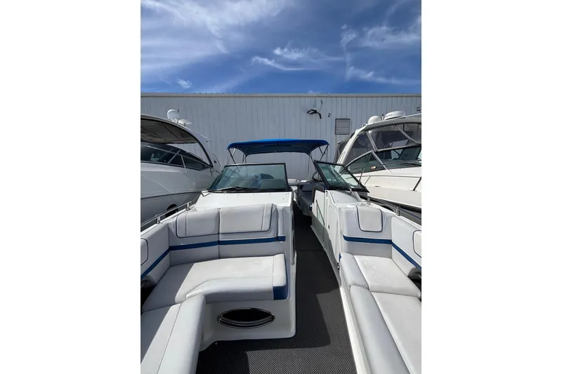 Slide: The Image of 2018 Formula 330 Crossover Bowrider I/O with spacious seating and blue canopy under clear sky. - 14