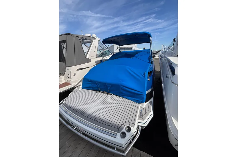 Slide: The Image of 2018 Formula 330 Crossover Bowrider I/O with blue cover docked at marina. - 26