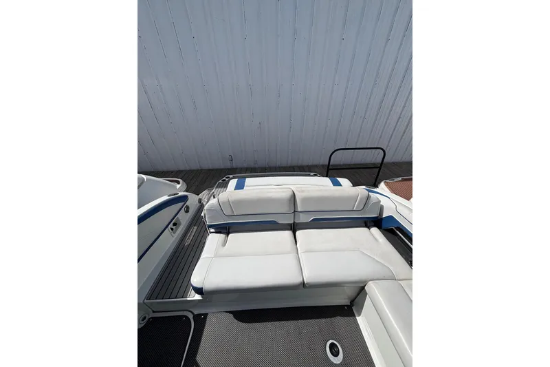 Slide: The Image of 2018 Formula 330 Crossover Bowrider I/O with white and blue seating, docked. - 3
