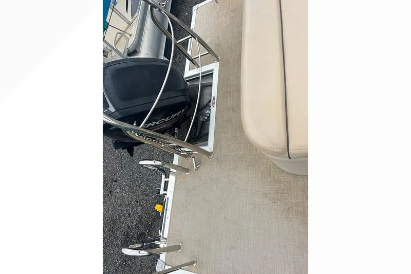 Slide: The Image of 2019 Harris Cruiser 210 boat deck with Mercury engine and beige seating. - 16