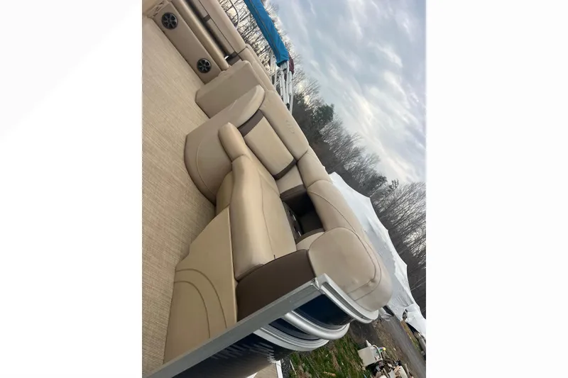 Slide: The Image of 2019 Harris Cruiser 210 pontoon boat with beige seating and outdoor setting. - 23