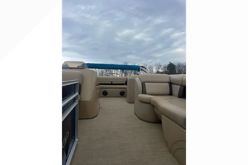 Slide: The Image of 2019 Harris Cruiser 210 pontoon boat interior with beige seating and blue canopy. - 24