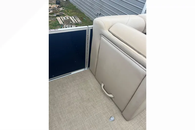 Slide: The Image of 2019 Harris Cruiser 210 interior with beige seating and storage compartment. - 26