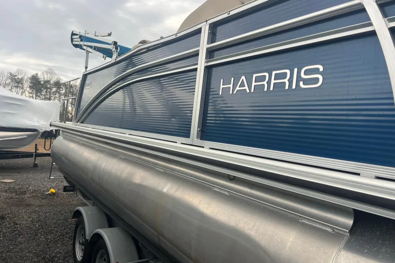 Slide: The Image of 2019 Harris Cruiser 210 pontoon boat with blue siding on a trailer. - 32