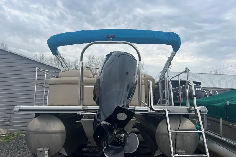 Slide: The Image of 2019 Harris Cruiser 210 pontoon boat with blue canopy and powerful outboard motor. - 33