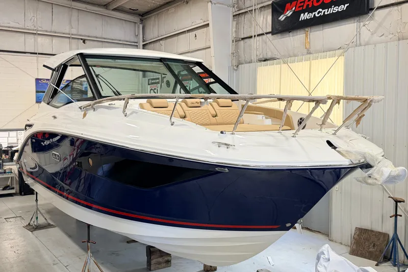 The Image of 2026 Sea Ray Sundancer 320 Coupe in a showroom, showcasing sleek design and luxury features. - 1