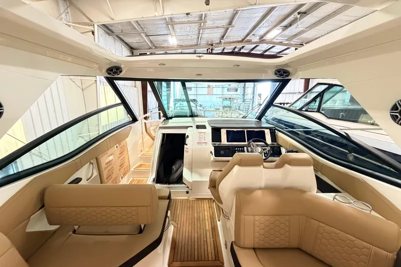 Slide: The Image of 2026 Sea Ray Sundancer 320 Coupe interior with luxurious seating and modern helm. - 11