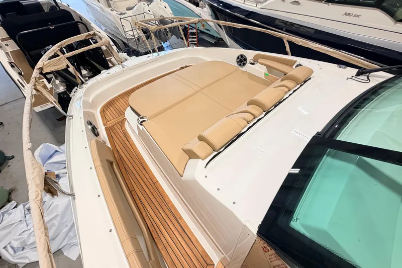 Slide: The Image of 2026 Sea Ray Sundancer 320 Coupe with tan seating and sleek design in a showroom. - 12