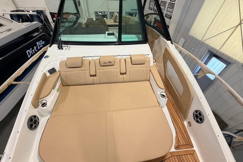 Slide: The Image of 2026 Sea Ray Sundancer 320 Coupe interior with tan seating and wood accents. - 13