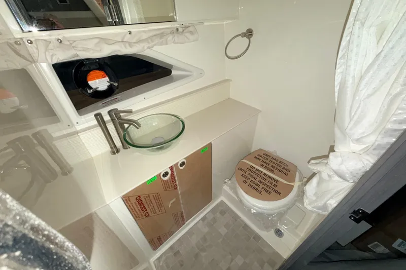 Slide: The Image of Bathroom interior of 2026 Sea Ray Sundancer 320 Coupe with modern fixtures and glass sink. - 16