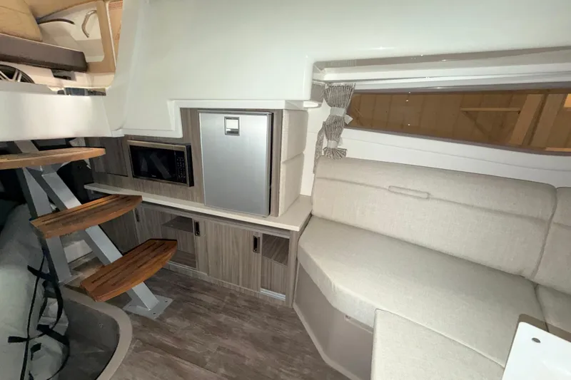 Slide: The Image of Interior of 2026 Sea Ray Sundancer 320 Coupe with modern seating and kitchenette. - 17