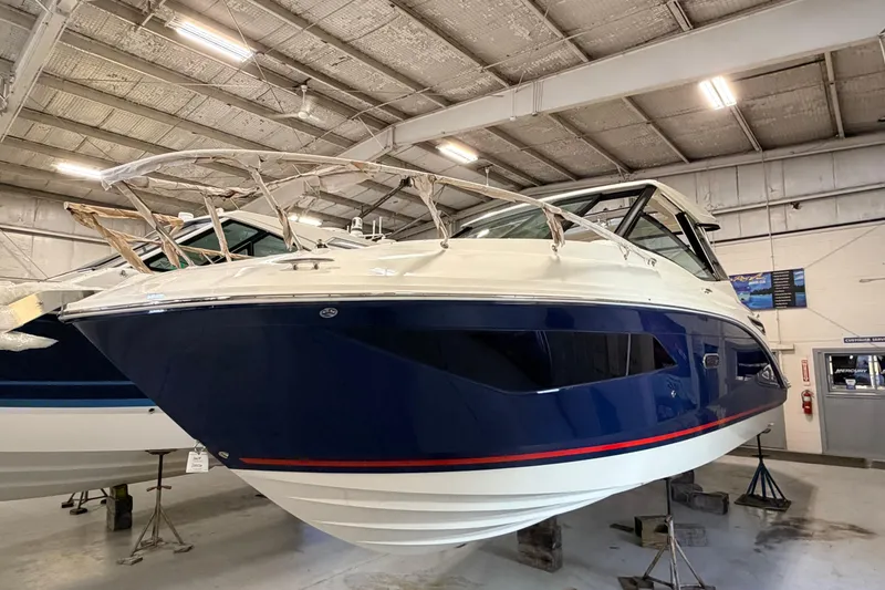 Slide: The Image of 2026 Sea Ray Sundancer 320 Coupe in a showroom, showcasing sleek design and modern features. - 3