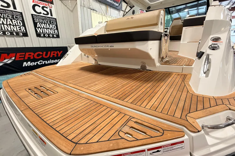 Slide: The Image of 2026 Sea Ray Sundancer 320 Coupe with elegant teak deck in showroom setting. - 4
