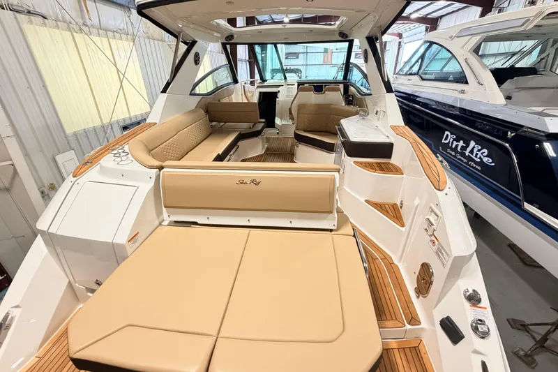 Slide: The Image of 2026 Sea Ray Sundancer 320 Coupe interior with beige seating and modern design. - 5